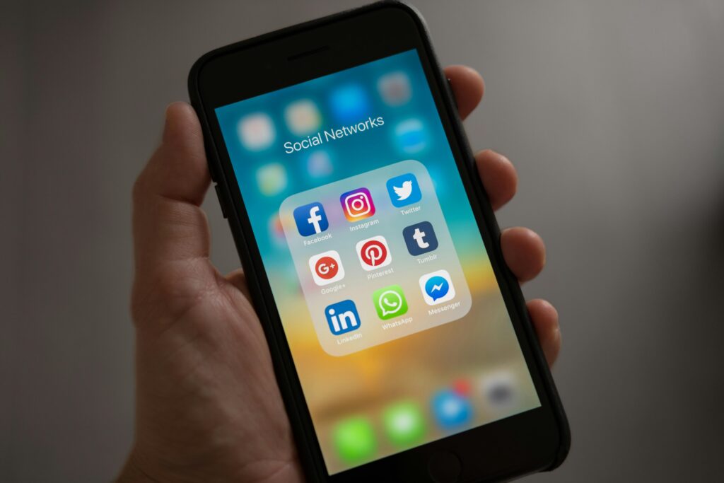 Création de site internet moderne – Utilisateur consultant les réseaux sociaux et outils de communication sur smartphone